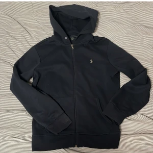 Ralph Lauren Hoodie - Tja säljer nu en riktigt snygg Ralph lauren hoodie i storlek M och i färgen marinblå i performance material. Hoodien är i ett fint skick utan några defekter som hål eller fläckar. Nypris 2395kr mitt pris 499kr. Hör av dig vid frågor eller funderingar! Pris ej hugget i sten!