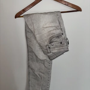 Replay jeans - grå - W30 L30 Snygga grå jeans från Replay med raka ben och klassisk femficksdesign. Jeansen har svarta kontrastsömmar och Replay-logga på bakfickan. Tillverkade i mjukt jeanstyg som sitter skönt hela dagen. Fickan har blivit modifierad för att man ska kunna få plats med mer. Nypris ligger runt 800 kronor.