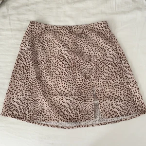Leopardfärgad kjol med en slits vid sidan - En leopardfärgad kjol med en slits vid sidan i storlek S som kommer från Shein. Kjolen har en dragkedja där bak. Den är lite för stor i storleken om man vill att den ska sitta ganska tajt. Den är helt oanvänd. Jag säljer denna söta kjol för att den är för stor för mig.