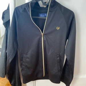 Fred Perry tröja  - Tröja i svart och guld från Fred Perry , storlek 36