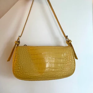 Axelväska gul - Gul axelväska. Bra storlek använd till o från i något år. Inga större slitningar eller missfärgningar. Ligger skönt på axeln. Köparen står för frakten.