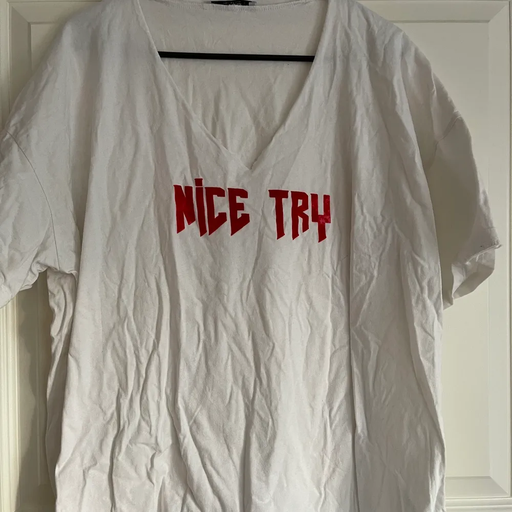 En vit T-shirt med röda texten NICE TRY. En kaxig tröja som går att styla till dem flesta tillfällen! Tyvärr är tröjan skrynklig då den legat i en låda för länge.. T-shirts.