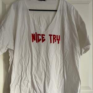 En vit T-shirt med röda texten NICE TRY. En kaxig tröja som går att styla till dem flesta tillfällen! Tyvärr är tröjan skrynklig då den legat i en låda för länge.