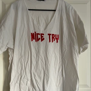 Vit T-shirt med Nice Try - En vit T-shirt med röda texten NICE TRY. En kaxig tröja som går att styla till dem flesta tillfällen! Tyvärr är tröjan skrynklig då den legat i en låda för länge.