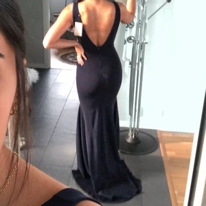 balklänning - elegant och snygg balklänning med släp. ganska tjockt och strechigt tyg (till ens fördel) i en marinblå färg. använd 1 gång på balen. jag är 172 och hade 8cm klack och tårna syntes precis. strl 36/38