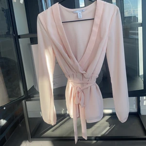 Omlottblus med knytning i midjan - Omlottblus från NLY TREND med knytning i midjan. Superfint material, endast använd ett fåtal tillfälle! Storlek 34 men skulle säga att den passar 36 också.