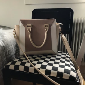 Väska  - Fin, rymlig väska i créme vit. Har beiga detaljer. 