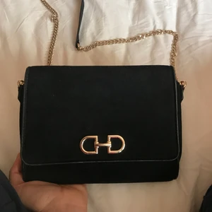 Handväska  - En enkel men väldigt fin svart väska med guldiga detaljer som går att ha till både vardags och fest. Använd ca:4-5gånger men fortfarande i väldigt fint skick. Gratis frakt✅ Endast swish✅ Skickar endast✅