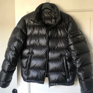 Prada puffer Strl 48 - Prada dunjacka i storlek 48/M. Den är i nyskick förutom (obs se bild!) ett millimeter litet lagat hål. Det syns inte men kan ändå vara bra att nämna. Säljes för mindre än halva nypriset.