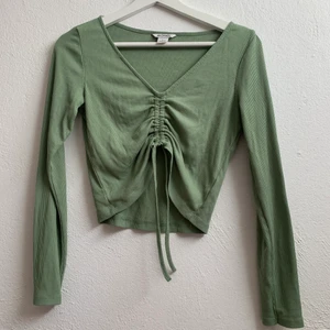 Grön topp - Säljer min jättesöta gröna topp från monki. Den har ett otroligt skönt ribbad och stretchigt tyg. Det går alltså att välja hur tajt man vill knyta snörerna där fram beroende på hur kort man vill att tröjan ska bli. Jag säljer tröjan på grund av att jag inte längre använder den. 🌸🌸🌸🌸