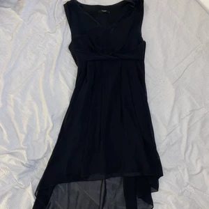 Svart klänning - Svart klänning med ett snurrat ”skärp” under brösten. Kjolen är längre bak och översta lagret är i mesh. Använd ett fåtal gånger men inga slitningar. Klänningen såldes som onesize, passar S-L