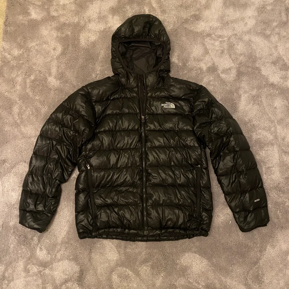 Svart dunjacka från The North Face. Inga hål eller revor i tyget. Storlek: M. Nypris ca 3500kr. . Jackor.