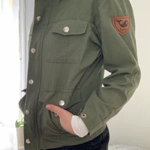 Tunn grön jacka - En jacka i tunnt material som är som gjord för att gå promenader på vår och höst. Okänt märke (köpt second hand) men det står ”lucas” på lädermärket på ärmen. En icke-avtagbar huva.🌱 ärmarna är rätt korta så sitter nog bäst på en xs.