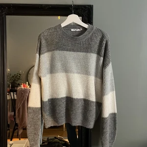 Randig stickad tröja - Stickad tröja från nakd. Randig i olika grå toner. Superfin men kommer inte till användning längre.