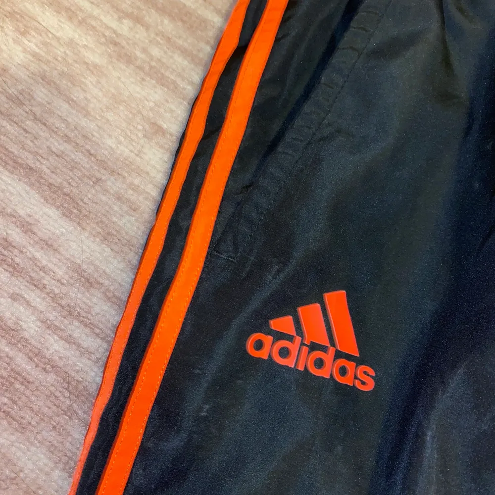 Adidas svart byxor med orange streck. Helt Ny skick! Använd endast 1 gång! . Jeans & Byxor.