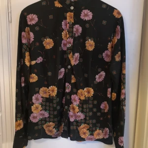 Retro skjorta eller blus - Retro skjorta eller blus från 60/70-talet. Mkt fint skick! I syntetmaterial. Uppskattar storleken till M.
