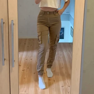 Beige/bruna cargobyxor, strl xs - Beiga/bruna cargobyxor från Madlady i storlek XS. Säljs på grund av att de inte används mer, och är knappt använda. På mig som vanligtvis bär S/36 i byxor passar dessa mig, men i en mer tight passform. Jag är 164 cm och de är lagom långa för mig. Säljs för 75 kr. Köparen står för frakten☺️