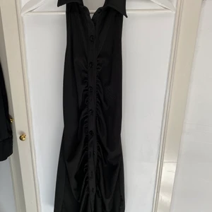 Svart halterneck klänning - Kort halterneckklänning med knäppe i mitten