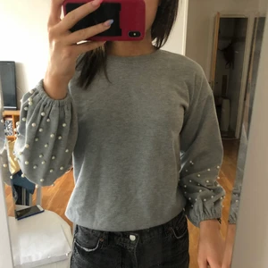 Grå tröja med pärldetaljer  - Grå tröja med pärldetaljer. Skön tröja med puffiga armar. Pärlorna sitter kvar efter tvätt, faller inte av. Original pris 400kr