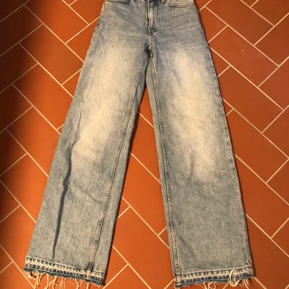 Ljusblåa jeans från monki i modellen yoko. Storlek 24. Har sprättat upp kanten och de är ganska nötta nere vid foten. Jeans & Byxor.