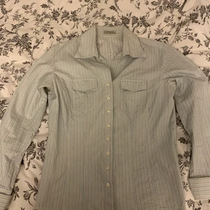 Skjorta i äldre modell - En skjorta i äldre modell. Superfin och sällan använd då den varit för liten länge men jag inte velat göra mig av med den. Vit och randig. Storlek L enligt lappen men jag skulle säga att den är mellan s och m. 