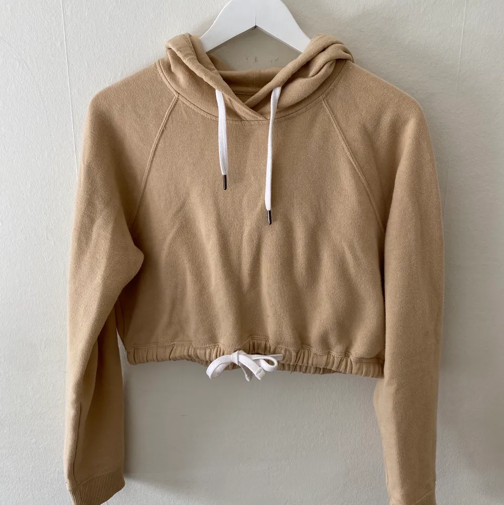 Snygg och mjuk croppad hoodie i en fin beige färg. Den är använd fåtal gånger. Skön att ha både när det är svalt och varmt då den inte är så tjock. Från Hollisteg. Säljer på grund av inte min stil längre så används inte. . Hoodies.