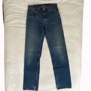 Vintage mörkblåa Levi jeans från 90-talet. Hög midja, djupa fickor och långa ben som går ner till marken på mig (175 cm). De är fortfarande i bra skick. Passar någon i storleken 36-38. 
