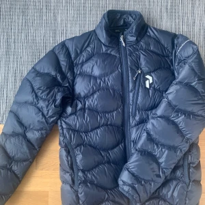 Peak performance junior helium jacka - Säljer en junior helium jacka. Storlek 160. Knappt använd.  Nypris 1600kr säljer nu för 600kr. Skickar på posten mot att köpare står för frakt. Står inte för postens slarv. 