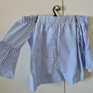 Blåvit randig off shoulder topo - Blåvit randig off shoulder top från new yorker i storlek xs som jag tror jag köpte för 169 kr. Skitsnygg till ett par högmidjade jeans eller shorts