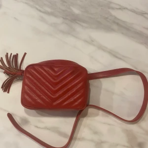 Magväska - Röd magväska eller Cross body om man vill det Har ett jack i bandet men fungerar att använda ändå