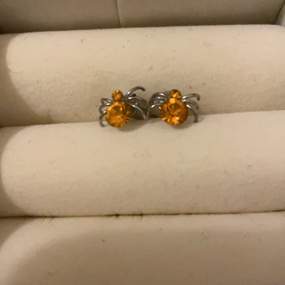 Ett par orangea spindel örhängen som jag fått i present  men alldrig använt. Köparen står för frakt!!. Accessoarer.