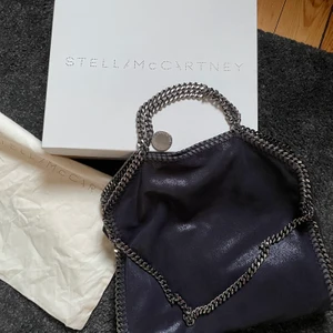 Stella McCartney falabella väska  -  KÖP DIREKT 2500kr!       Stella McCartney väska i mycket fint skick! Väskan är i en stor och rymlig modell (får plats en dator).  Nypris för denna modell är ca 8000kr   Färgen är marinblå.  Dustbag och kartongen medföljer! Kvittot finns tyvärr inte kvar då jag fick denna i present för några år sedan.  Varan skickas när pengarna sitter på kontot! Högsta bud vinner!