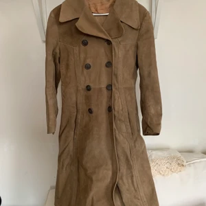 Klassisk vintage mockakappa i mycket fint skick - Livets mockakappa i storlek S - den här kappan är helt fantastisk. Det är min mammas från början och sen har jag använt den, men nu är den tyvärr för liten för oss båda. Den är riktigt fint bevarad (om än lite skrynklig efter att ha legat nerpackad), men vackert skimrande foder och slät mocka. Alla knappar kvar dessutom! Står storlek 44 i nacken, passar en XS-S.