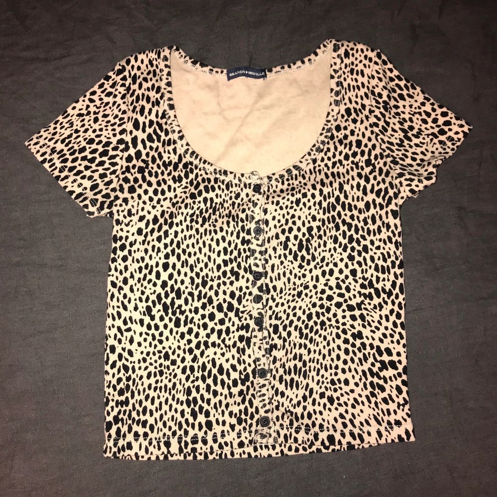 Nypris €18 plus €7 frakt. New without tags Brandy Melville Cheetah Print Mönster Zelly Short Sleeve Crop Top. Fitted ribbed crop top in cheetah print with a scoop neck and button down detailing. Fabric 100% cotton. Measurements: 40 cm long, 30 cm bust. Made in Italy. Tag size OSFA