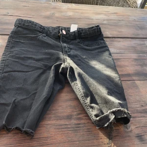 Ett par svarta jeansshorts☺️ - Jag säljer dessa svara jeansshorts med dragchedja och knapp☺️Små trådar som sticker ut på Båda Ändar av shortsen💞använd 3-4 gånger och är i bra skick👍🏻