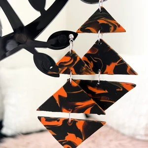 Örhängen Orange/svarta - Örhängen är gjorda av   fimolera Färgen kan skiljas i verkligheten   Följ min Instagram för mer @clay_konst Står ej för postens slarv 