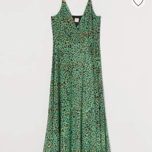 En charmig mönstrad grön klänning från H&M, enbart använd ett fåtal gånger. Eftersom det är en omlottklänning så är den justerbar runtom samt att man kan justera banden på axlarna. Ordinariepris 159kr