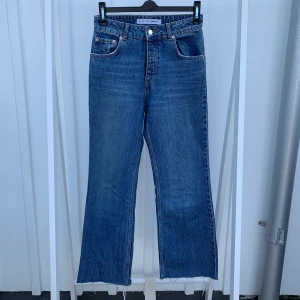Blåa jeans från Anine Bings kollektion med Gina tricot - Blåa supersnygga jeans i en kortare och rak modell. Använda men i väldigt fint skick. Är i storlek 34-36 men saknar stretch så skulle säga att det är mer av en 34:a. Nypris: 599kr