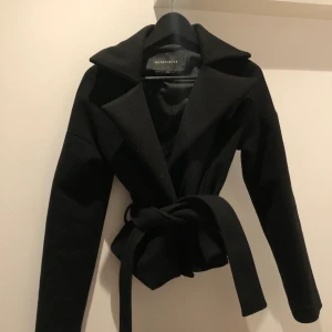 Kort kappa NAKD - Kort kappa med knytning i midjan ifrån NAKD. Färg svart!!!! Storlek XS. 200kr utan frakt!