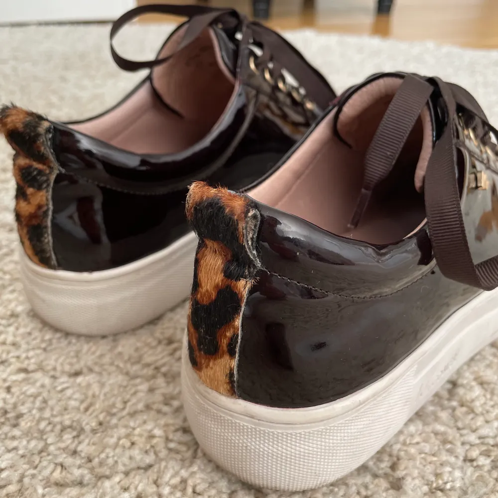 Säljer sneakers från K.COBLER. Dessa är mörkbruna lack med leopard detalj vid hälen. Säljer då de inte kommit till användning. Endast använda 1 gång, som nya därav priset. Nypris : 1000kr. Skor.