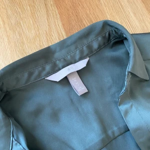 Skogsgrön skjorta  - Jättefin färg och super skönt material. Passar bra till våren eller att ha över bikinitopp på sommaren. Endast använd 1 gång så i nyskick. Köparen står för frakten.