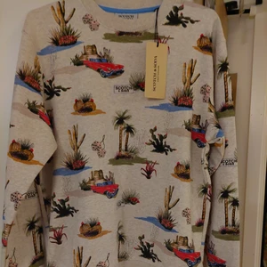 Sweatshirt/ Tröja  - Långärmad, mönstrad Allover Printed Crewneck sweatshirt från Scotch & Soda. Sweatshirten har en rund halsringning och en ribbad mudd.   Tröja är helt nytt. Ordinarie pris är 999kr 