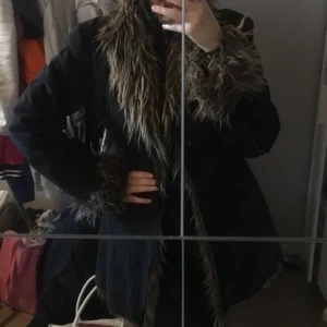 Kappa med fejkpäls - Medellång kappa med fejkpäls. Två knappar inga fickor. Jättefin och mysig ☺️. Stl L, skulle mer säga liten L elr stor M. Är själv 168 cm och bär s/m/40 i stl för referens. Använd en gång. SÅLD
