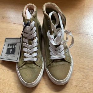 Frye sneakers helt nya - Så snygga sneakers från underbara Frye. Helt nya och oanvända då de tyvärr var för små för mig.  Köpta som storlek 38 men är 37-37,5. Ny pris över 1000kr.  Äkta skinn. Kvalitetsko som kommer hålla länge och bli snyggare med tiden!  Frakt tillkommer 70kr 