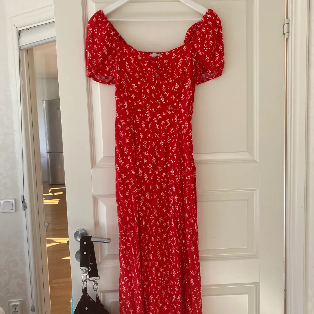 En blommig röd klänning i storlek 36 från & other stories i modellen Flowy puff sleeve Midi dress. Använd 1 gång. . Klänningar.