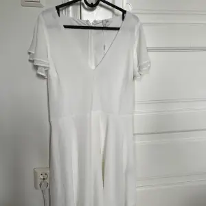 Jag säljer en oanvänd vit klänning med volang ärmar. I midjan har den ett snöre som sedan knyts åt. Prislappen är kvar. Jag säljer denna klänning då jag hittat en annan till min student. 