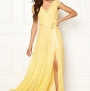 Viola Lace Gown Yellow - OBS. Sidenband saknas, använd 2 gånger.                        Material: Yttertyg: 90% polyester, 10% elastan. Foder: 100% polyester. Tvättråd: 30° skontvätt. Modellens längd & Storlek: 176 cm | small Vacker långklänning helt i spets från MOMENTS NEW YORK. - Tillverkad i en kvalitét med lite stretch - Smickrande V-ringning - Lätt vadderade kupor - Dold dragkedja i ryggen - Avtagbart knytband i midjan - Slits fram - Klänningens längd från axeln: 160 cm i storlek 36 - Midjemått: 70 cm i storlek 36
