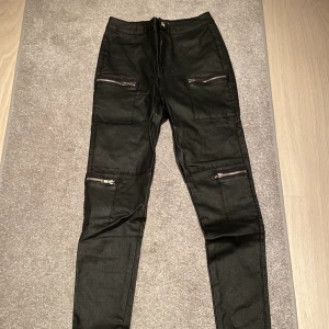 Skin/läder byxor med dragkedjor  - Skit snygga läder/skin (fake) byxor som inte kommit till användning då de är för små. Jag har ett par större som jag har på mig på bild 2. Köpte de för ungefär 2 år sen på missguided men det finns inte längre att få tag på💕