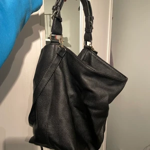 Väska - Svart väska från H&M. Fint skick, endast någon reva. köparen betalar för frakten.