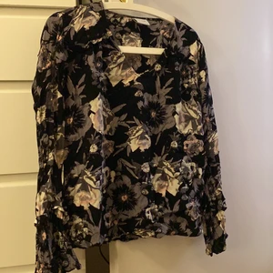Blus - En jättefin blus / tröja från vila. Den har lite fladdriga ärmar längst ut och jättefint blommönster!